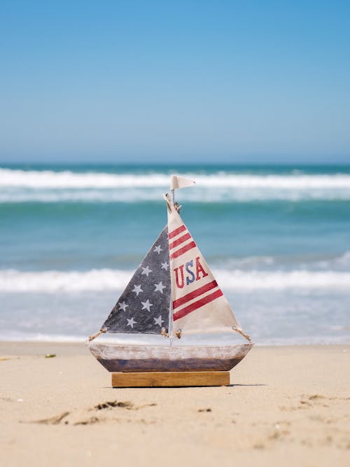 A Mini Wooden Sailboat on Beach