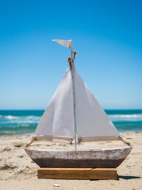 Free Brown and White Sailboat on Beach Stock Photo