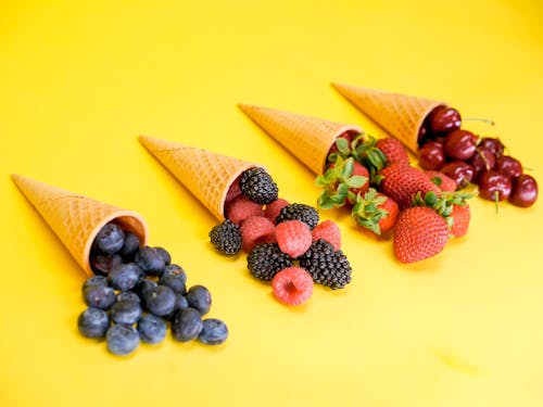Free Fruits and Cones on a Yellow Surface Stock Photo