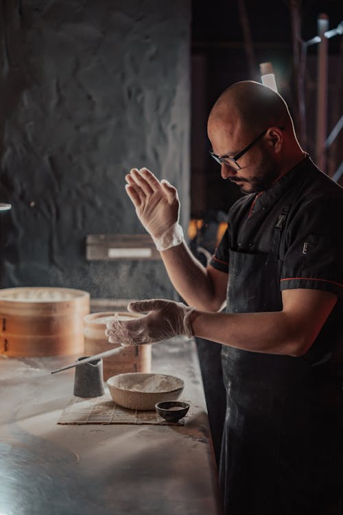 Photo of a Chef Wearing a Black Apron, Preparing Chinese Dumplings
