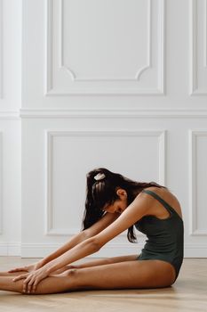 Elegant woman in athletic wear stretching indoors. Perfect for fitness and lifestyle themes.