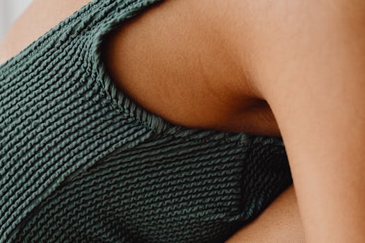 Detailed close-up of a person's arm wearing a green textured fabric, side view.