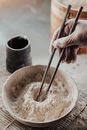 Person Holding Silver Spoon and Round White Ceramic Bowl