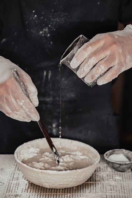 Person Making a Hand Mix Dough on Bowl