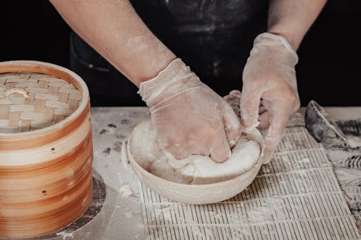 Close-up of hands kneading dough in preparation for making dumplings.