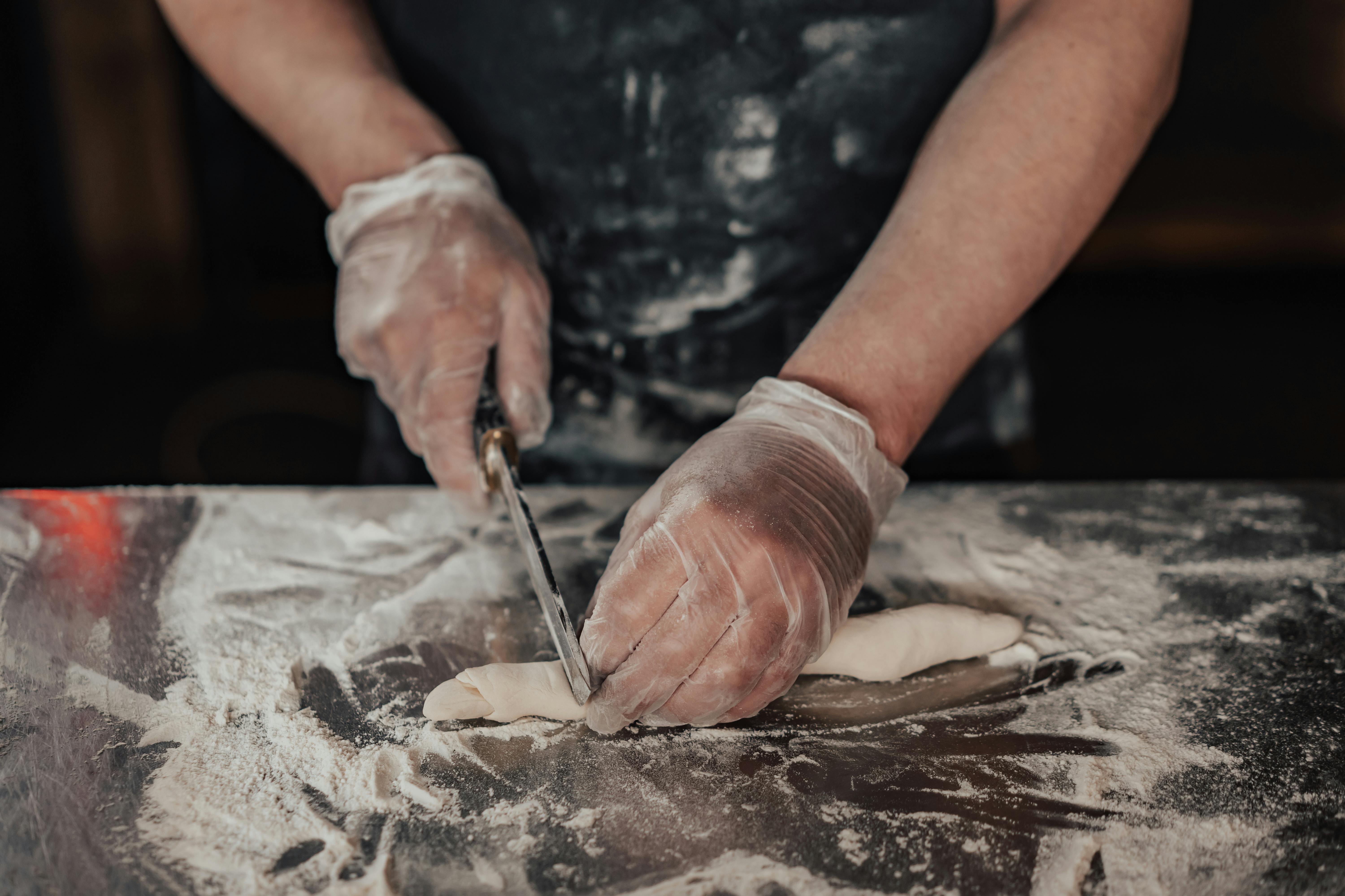 a person cutting dough