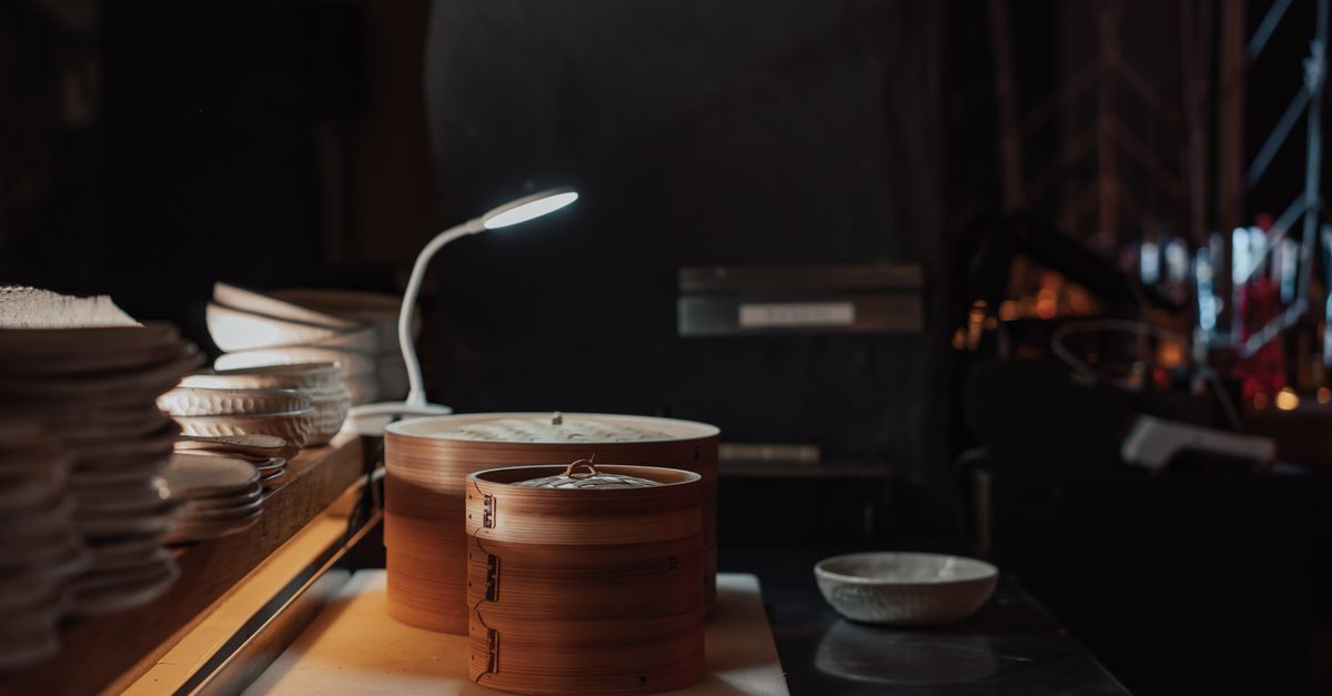 Warm restaurant setting featuring a bamboo steamer and ambient lighting.