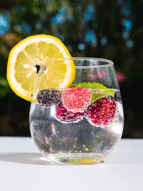 Clear Drinking Glass With Sliced Lemon and Strawberry