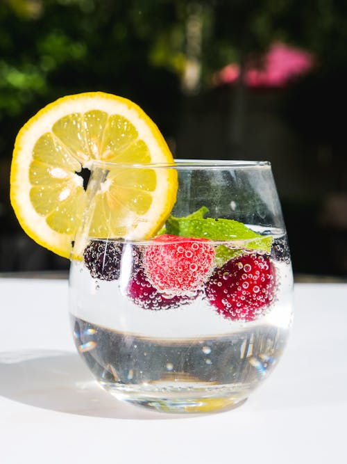 Clear Drinking Glass With Sliced Lemon and Strawberry