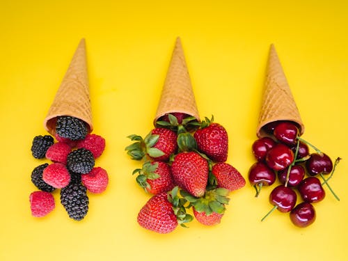 Ice Cream Cones and Fruits on Yellow Background