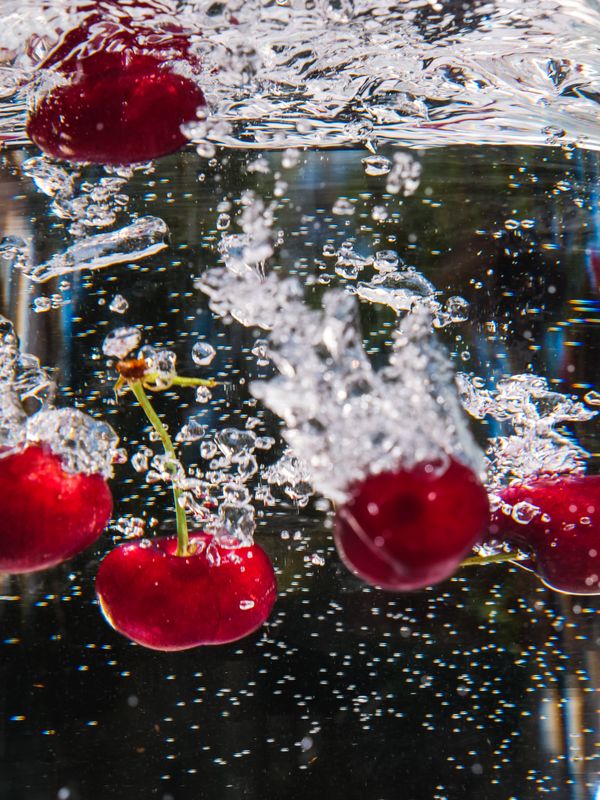 Vibrant red cherries plunging into sparkling water