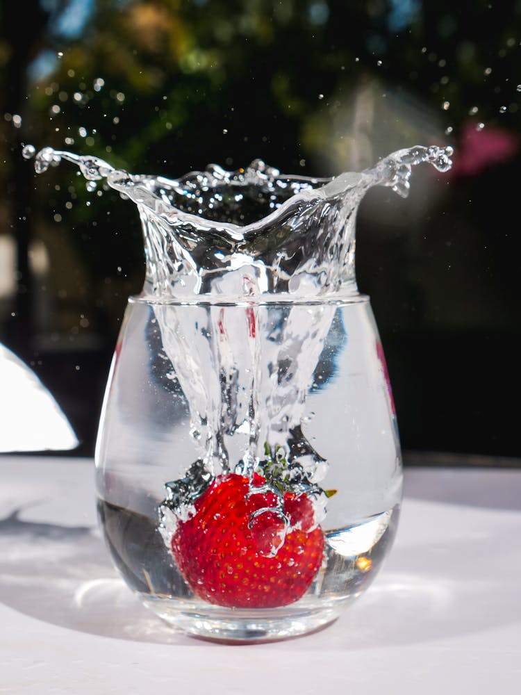 Dropping A Strawberry On A Glass Cup