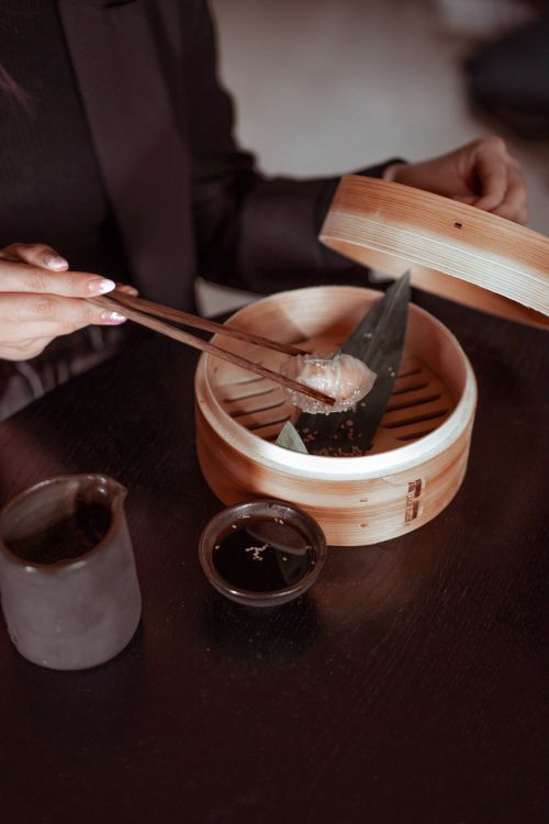 Free Close-up of delicious Asian dumplings in a bamboo steamer with sauce. Stock Photo