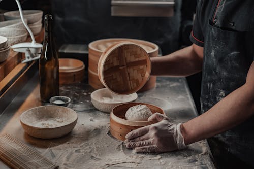 Free A Person Covering the Bamboo Steamer with Dough Stock Photo