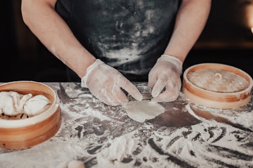 Free A Person Making a Dumpling while Wearing Gloves Stock Photo