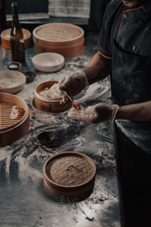 Person in Black Cook Uniform Making Dumplings