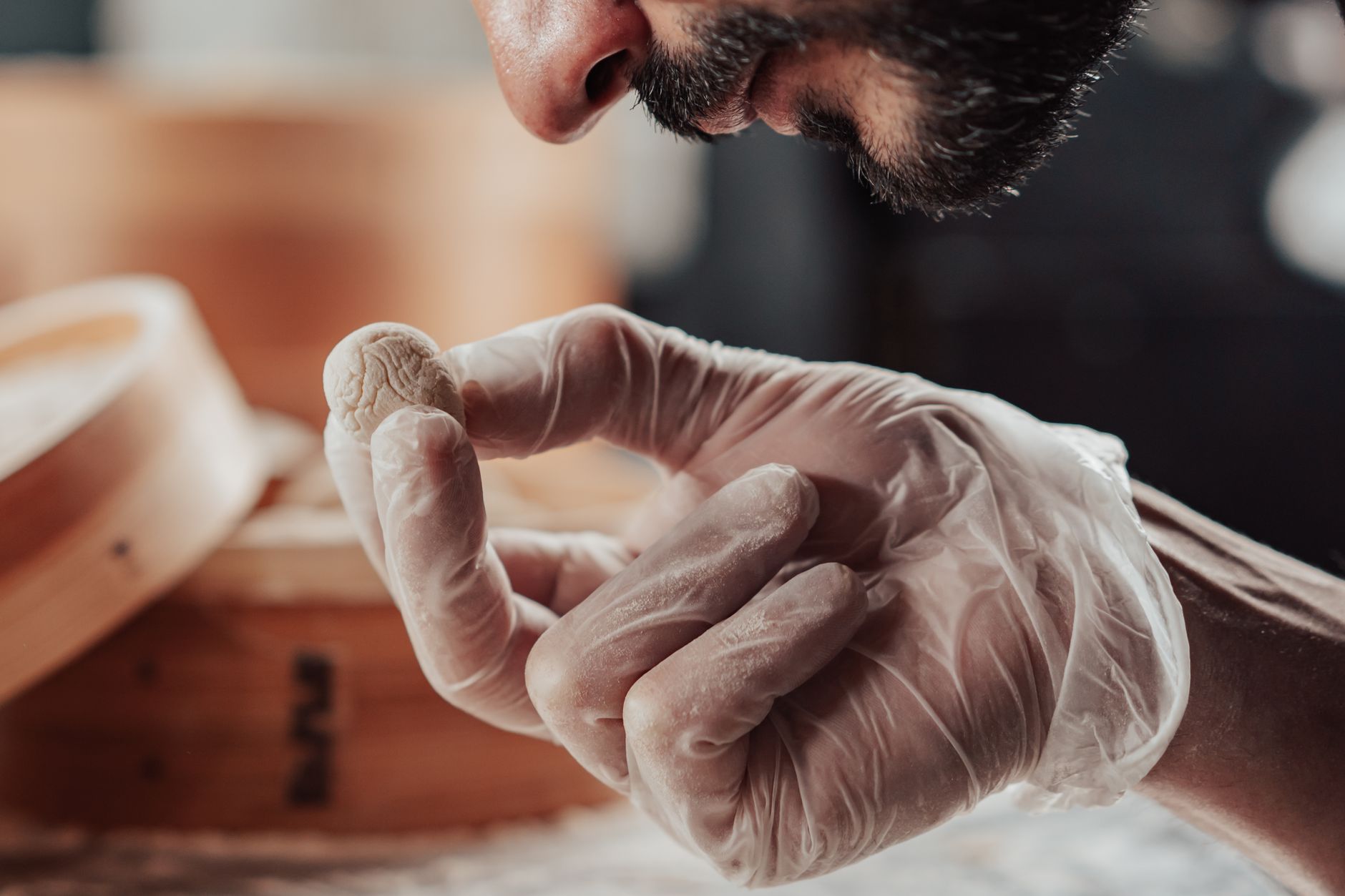 A luxury specialist in white gloves carefully inspecting a rare archival object in a minimalist studio setting.