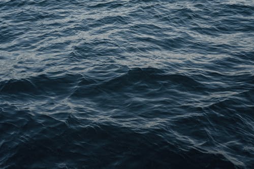 Free From above of wavy dark blue ocean with ripples on surface in daytime Stock Photo