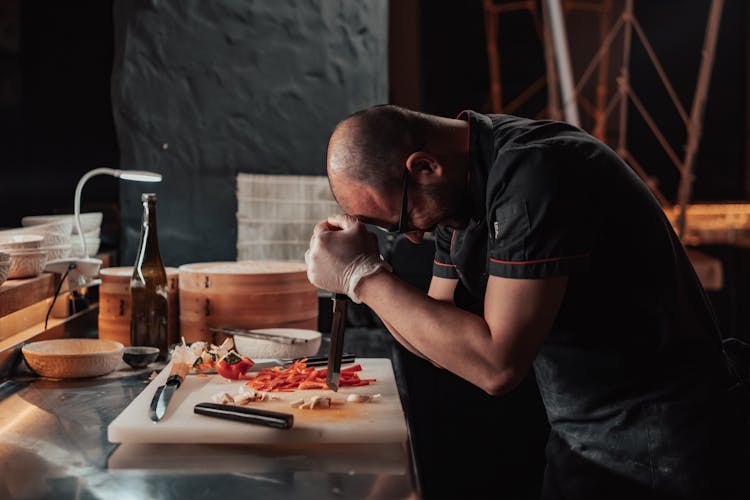 Bald Man Bowing While Holding A Knife 