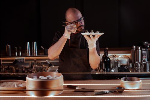 Free A chef expertly prepares dumplings in a cozy restaurant setting, focusing on detail. Stock Photo