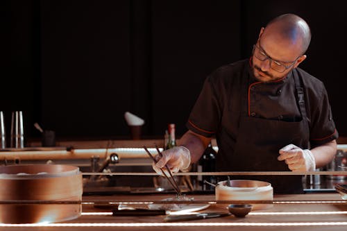 Man Wearing an Apron Preparing Food at the Counter