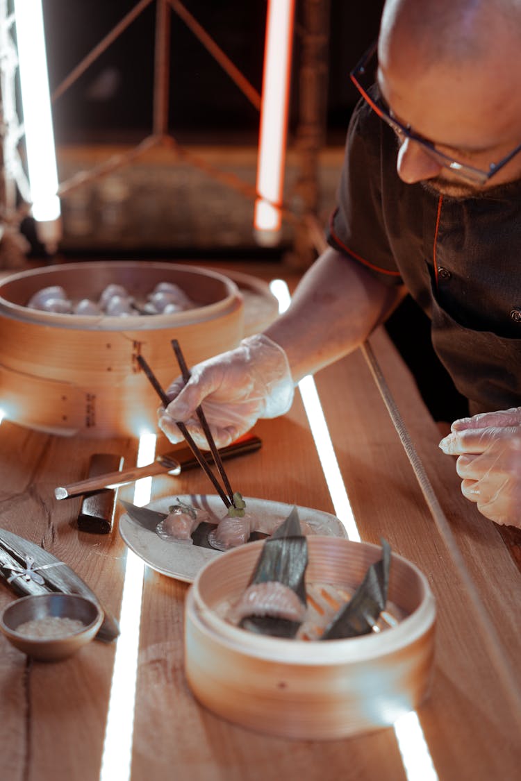 A Man Preparing Food Using Chopsticks