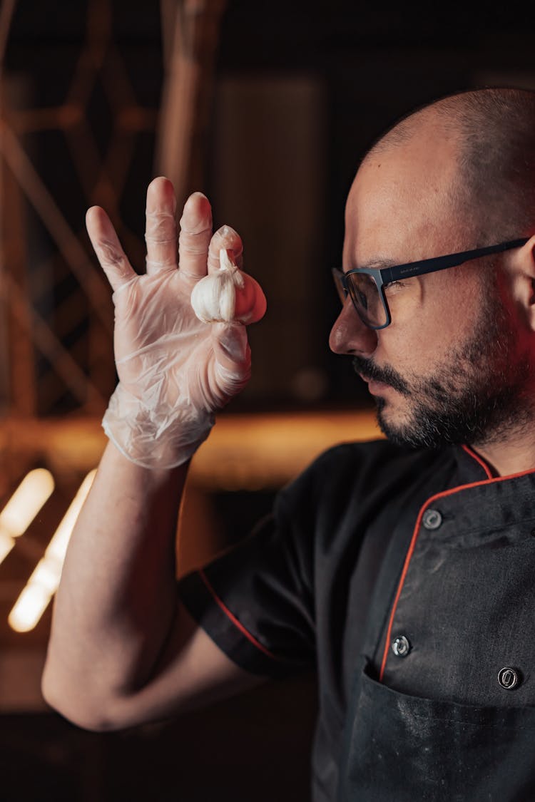 A Chef Meticulously Looking At A Garlic