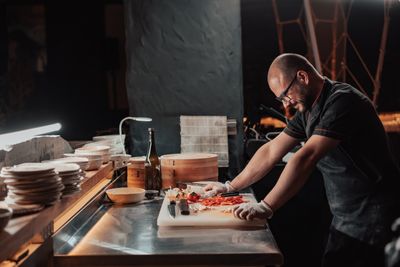 Chef slicing peppers at a prep station — photo by Mikhail Nilov on Pexels