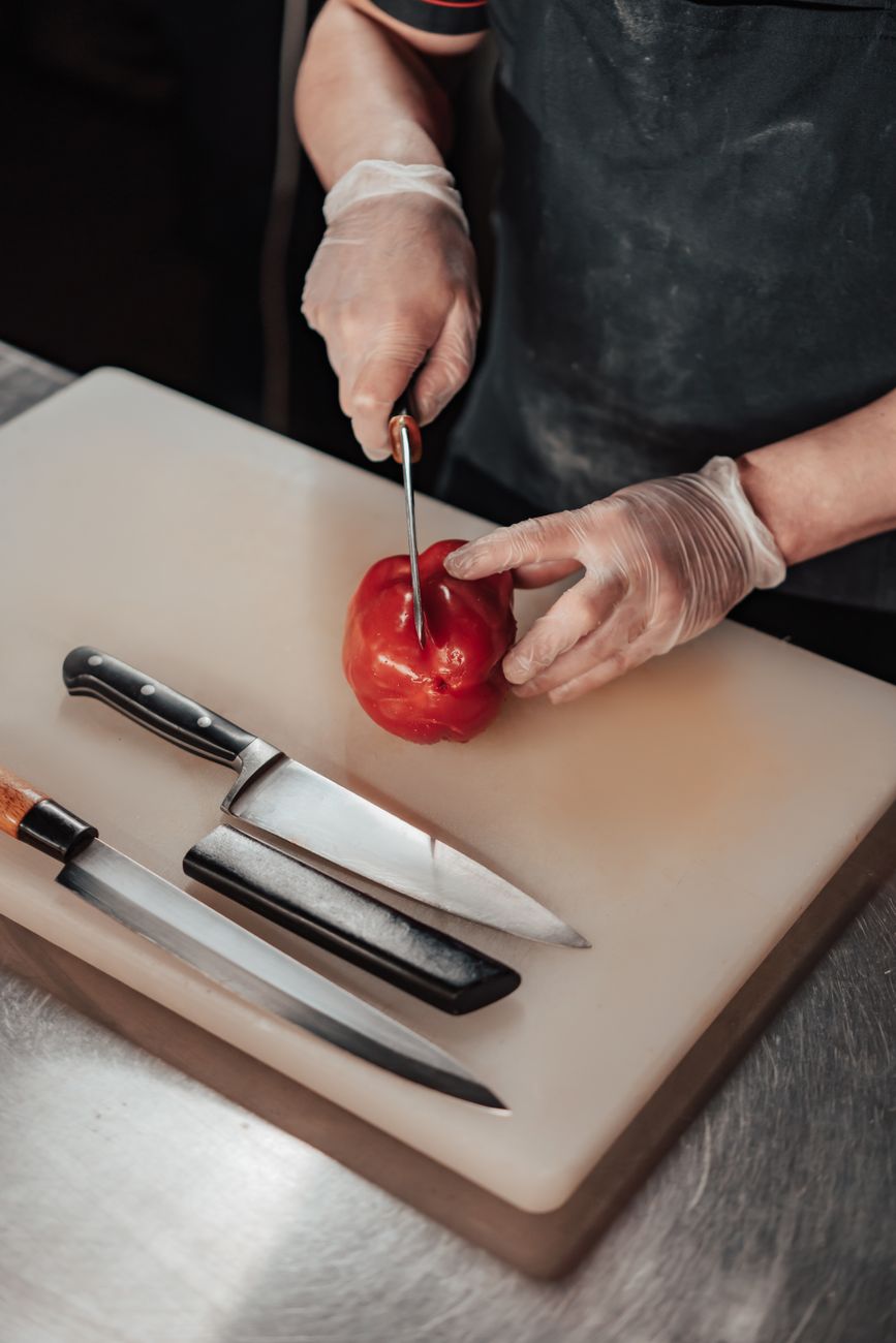 Balfood Kitchen chef chopping vegetables on a stainless steel counter