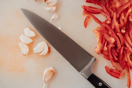 Close-Up Photo of a Sliced Ingredients with a Knife on Cutting Board