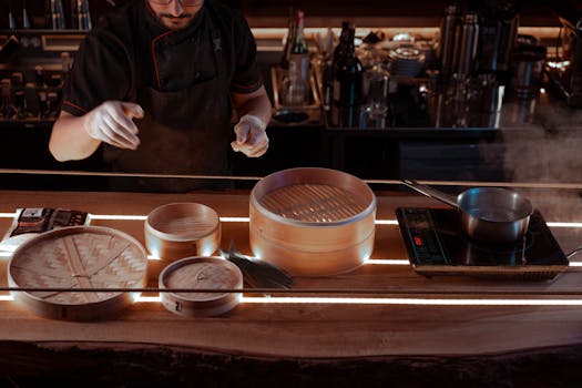 Chef in a kitchen setting using bamboo steamers to prepare Asian cuisine.