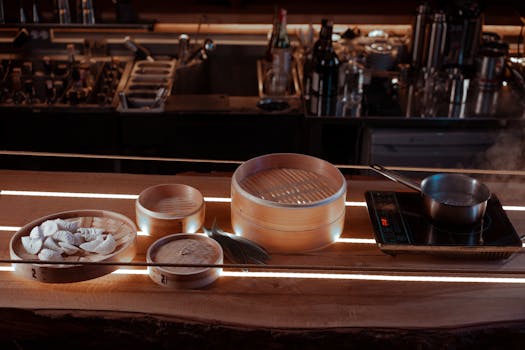 An inviting kitchen setup featuring bamboo steamers, dumplings, and a pot on an induction stove.
