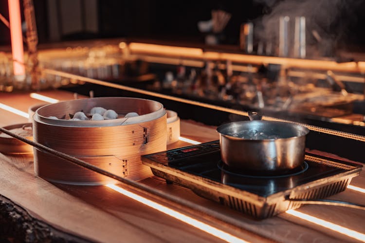 Bamboo Steamer Near A Stainless Pot On A Stove