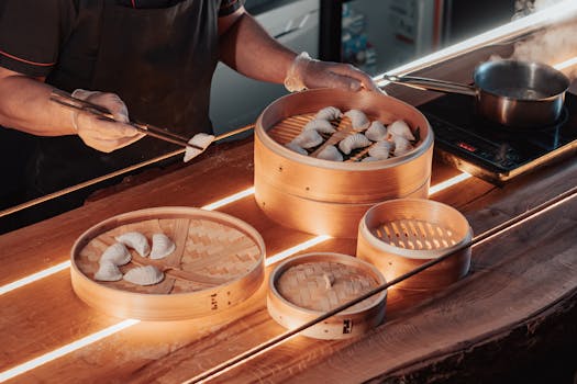 A cook prepares dumplings in bamboo steamers, highlighting Chinese cuisine and culinary skills.