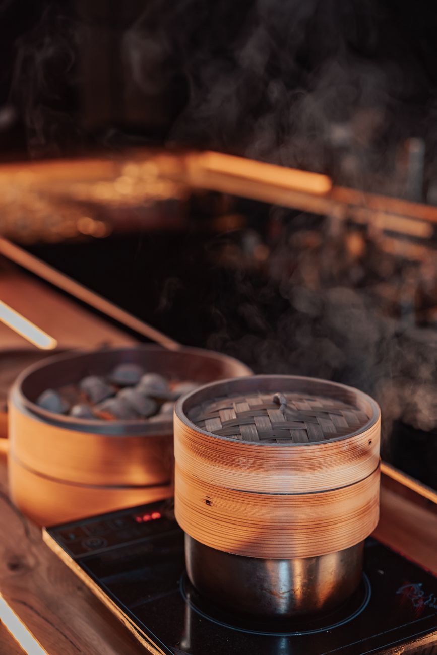Steam rising from stacked dumpling baskets, a reminder that flavour often arrives with moisture intact