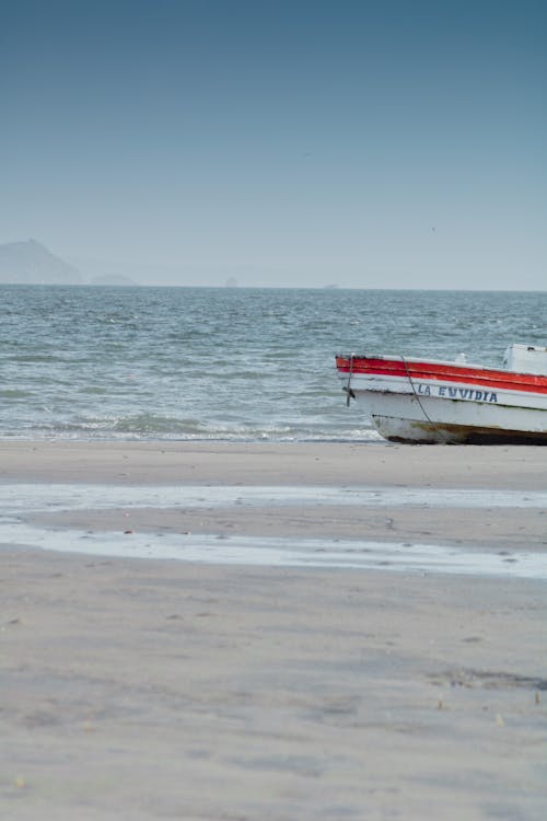 Red and White Boat on a Seashore