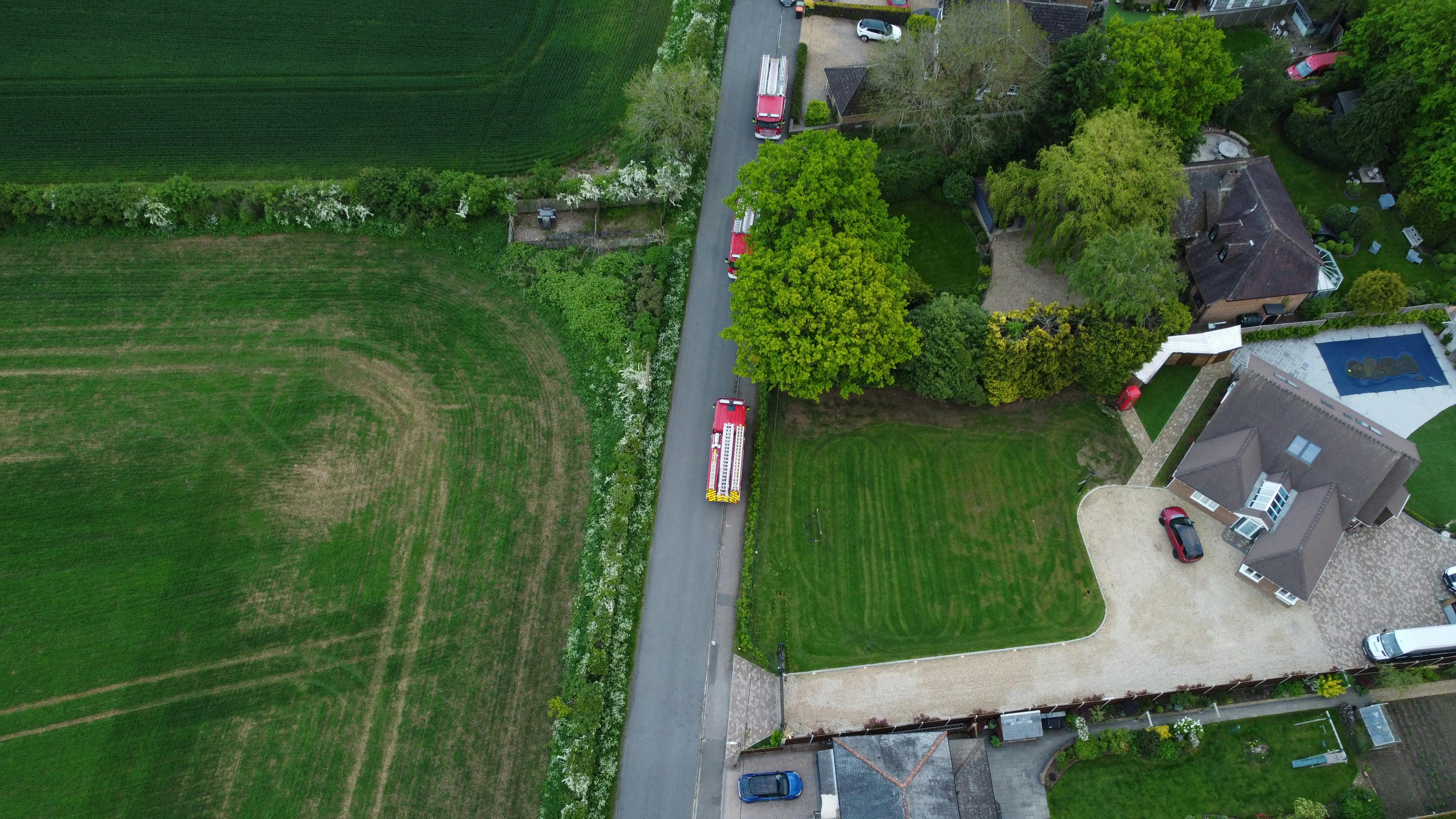 Aerial shot of Streatley with green fields, houses, and vehicles.