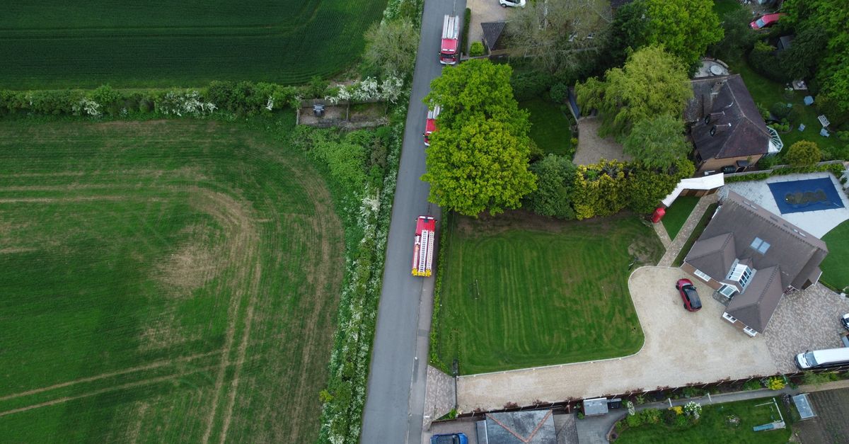Aerial shot of Streatley with green fields, houses, and vehicles.