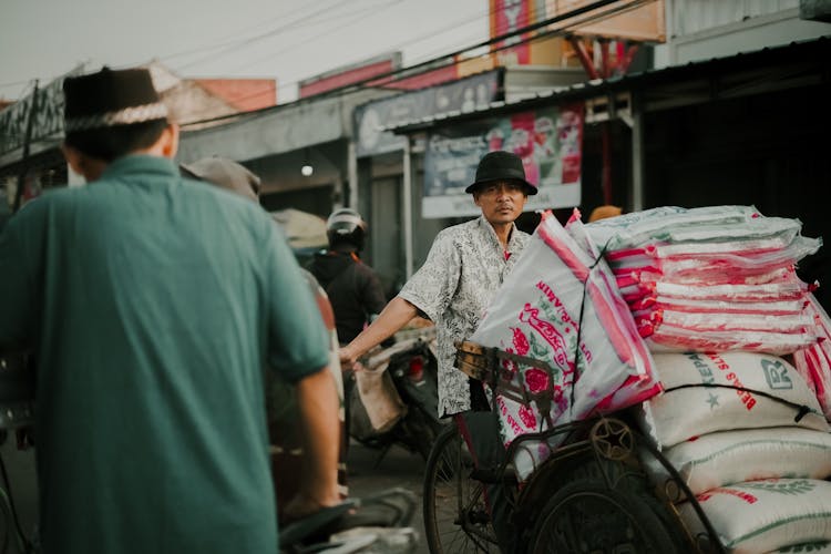 Asian Man With Bags On Crowded Market