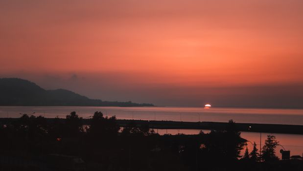 Experience the breathtaking sunset over the Ordu coastline in Turkey with vibrant orange skies reflecting on serene waters.