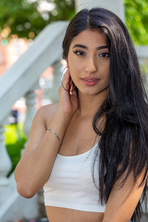 Portrait of a Woman in a White Crop Top Posing with Her Hand on Her Neck