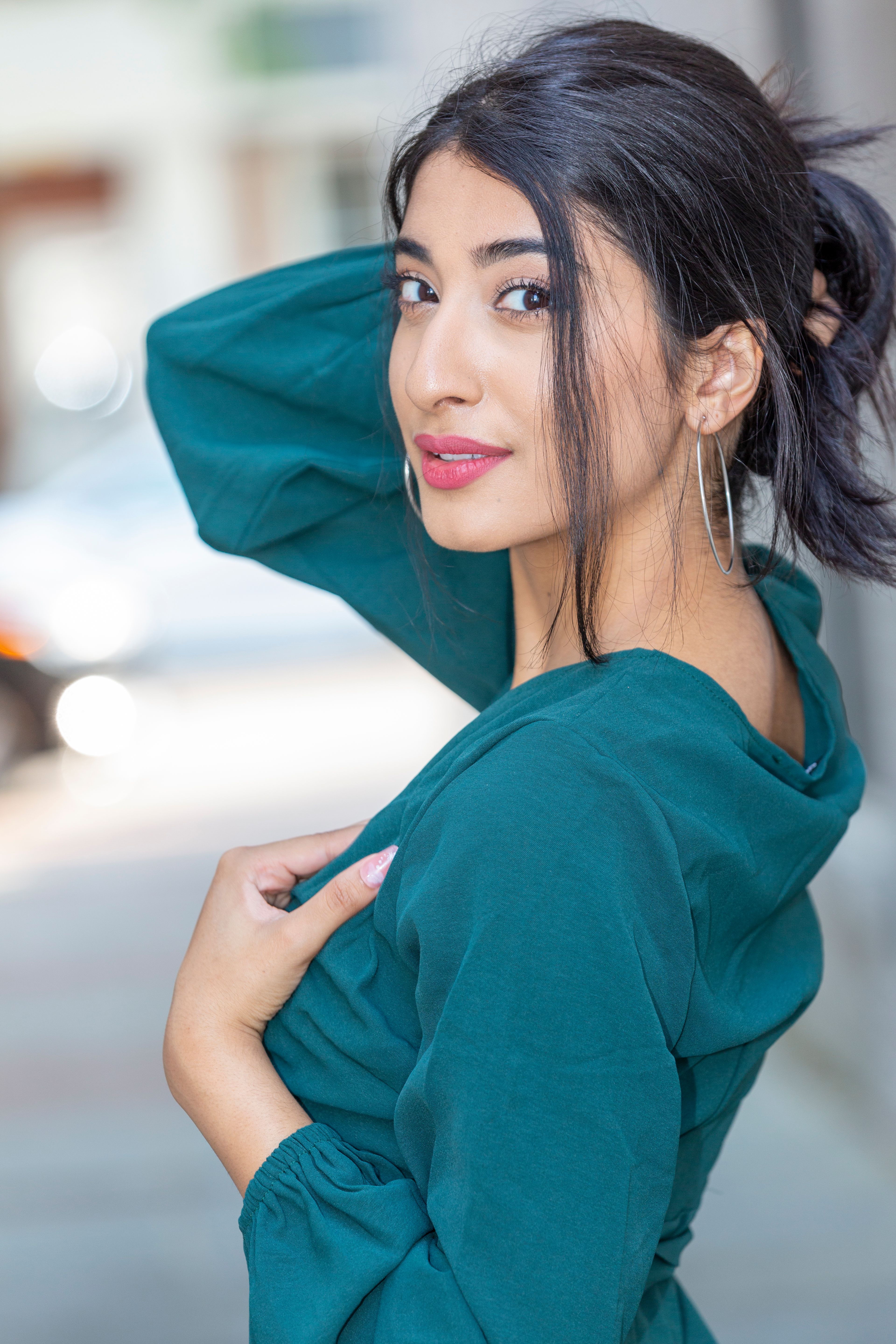 Stylish portrait of a woman in a green dress with urban background.