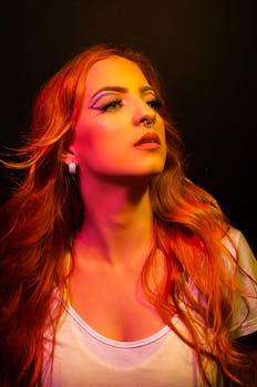 Striking portrait of a young woman with vibrant lighting and bold makeup.