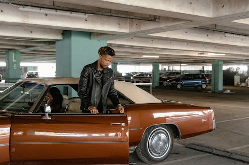 Free Man in Black Leather Jacket Going Out of the Car Stock Photo