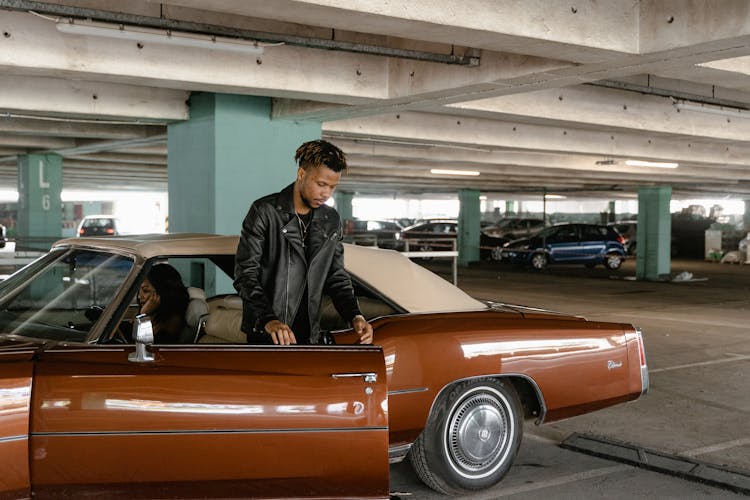 Man In Black Leather Jacket Going Out Of The Car