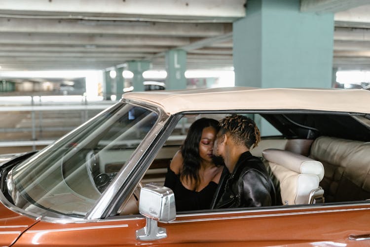 A Couple Kissing Inside The Car