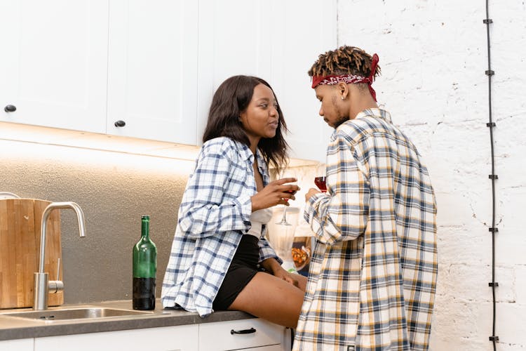 A Couple Drinking Wine In The Kitchen