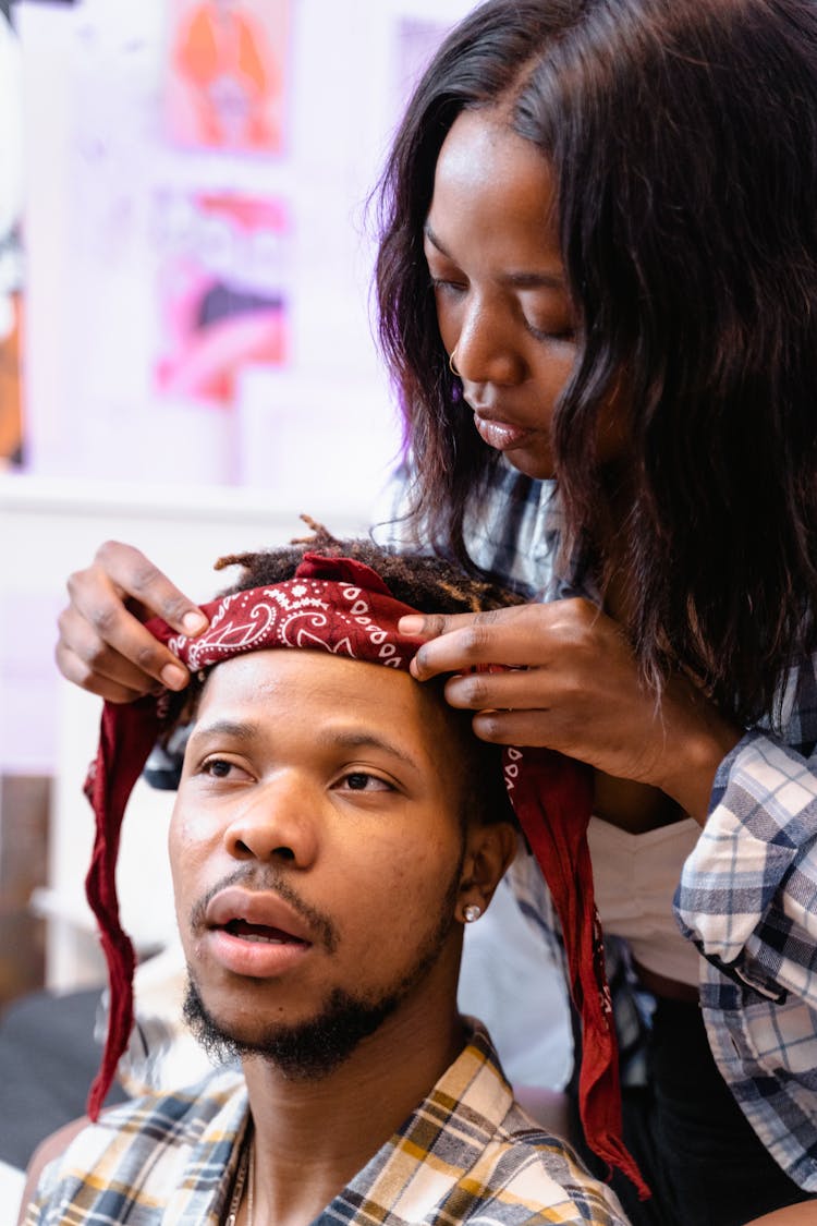 Woman Putting On A Bandana On Man's Head