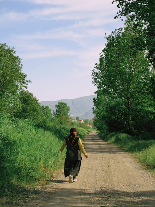 A Person walking on the Dirt Road