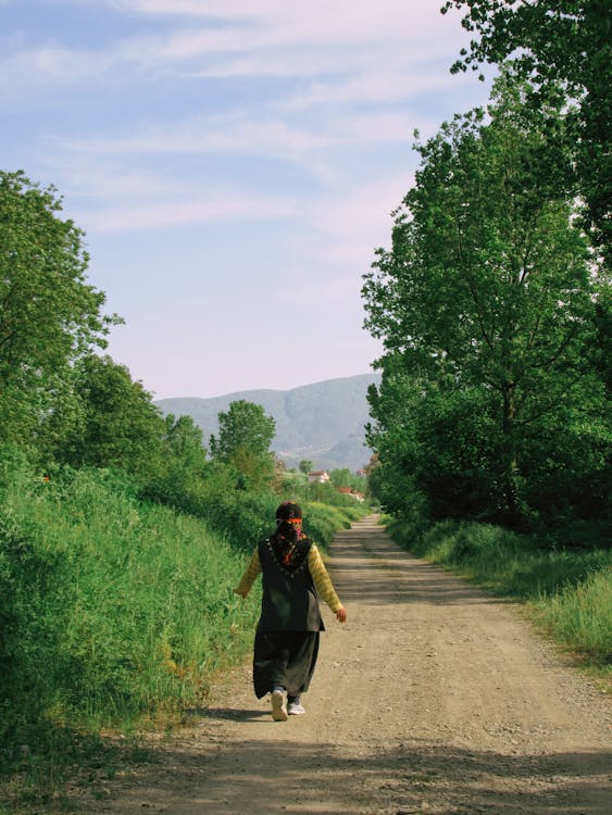 A Person walking on the Dirt Road